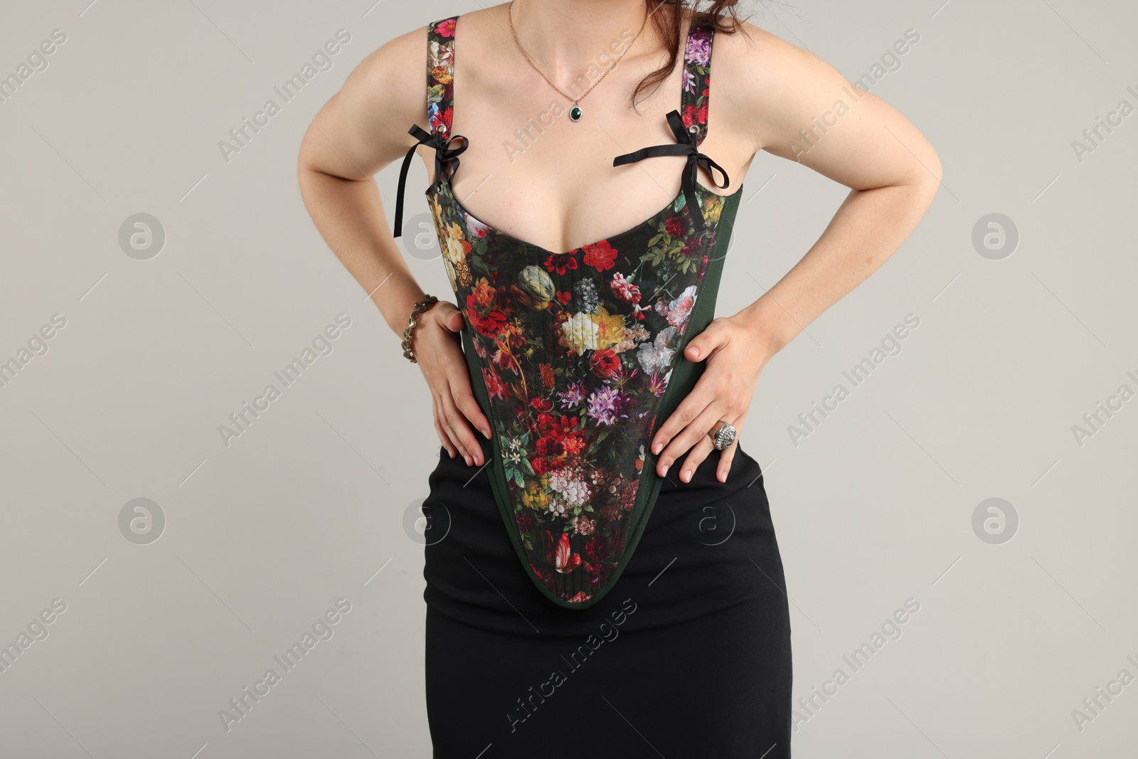 Photo of Woman in stylish corset on light grey background, closeup