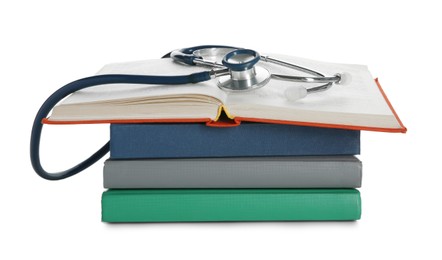 Stethoscope on stack of books against white background