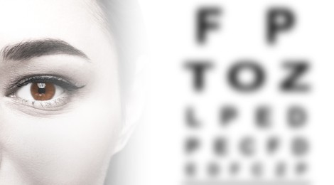 Snellen chart and closeup of woman's eye on white background, banner design. Color toned