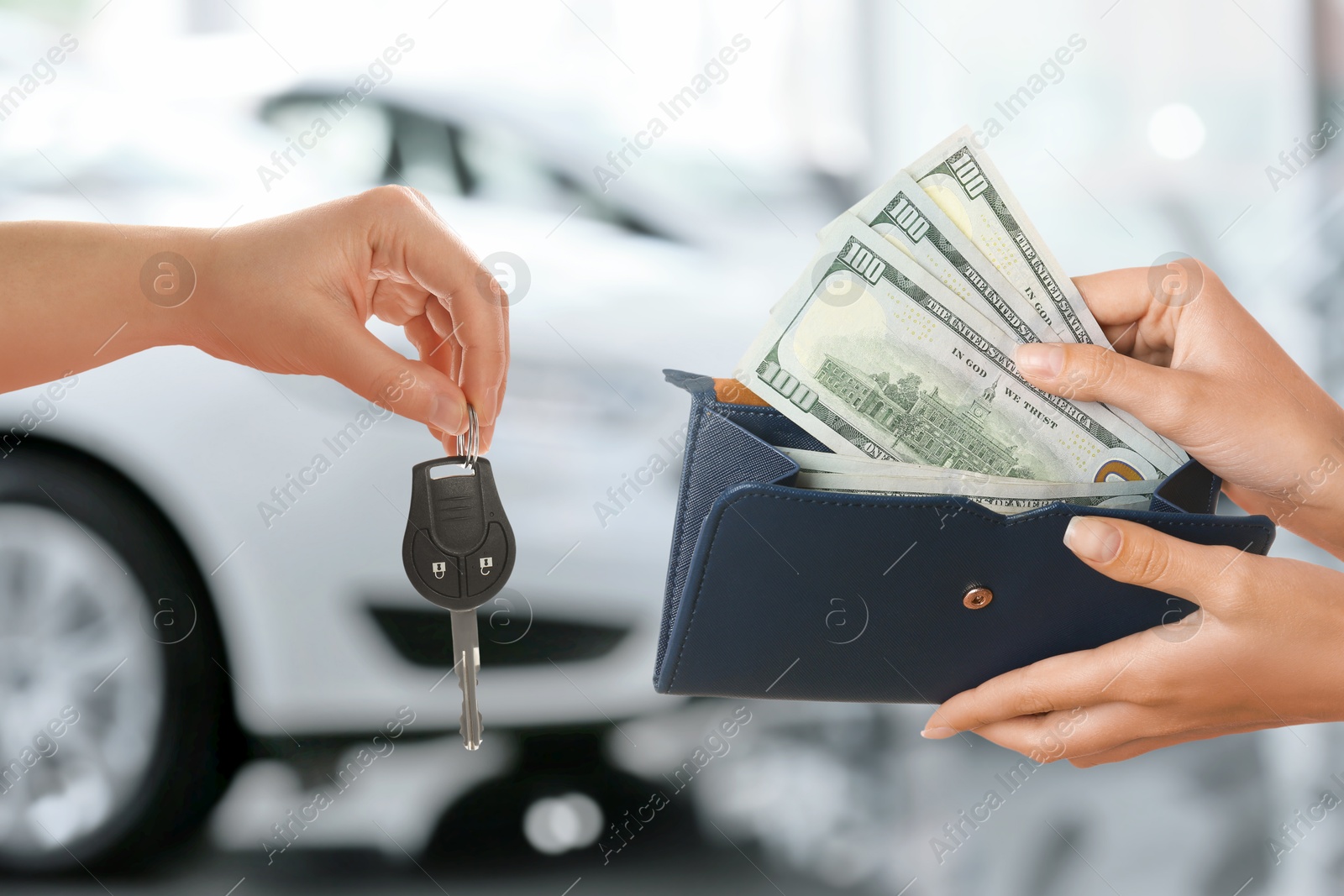 Image of Woman giving money to seller in exchange for car key in shop, closeup. Buying auto