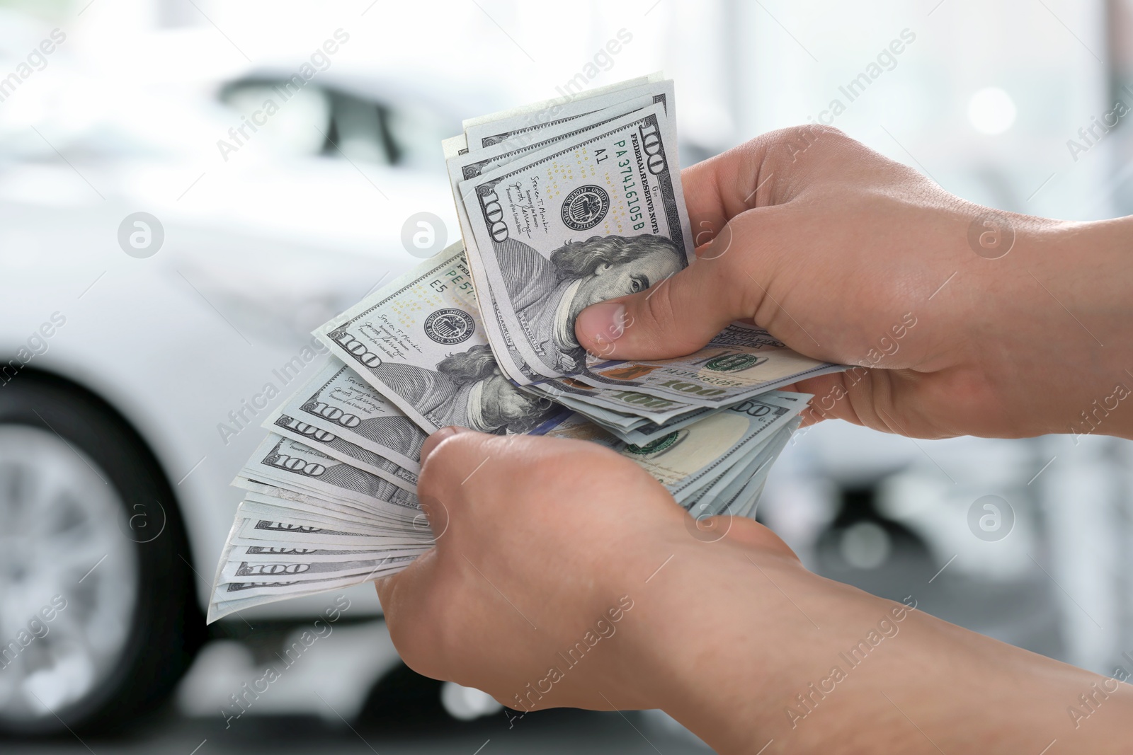 Image of Man with money in automotive shop, closeup. Buying car