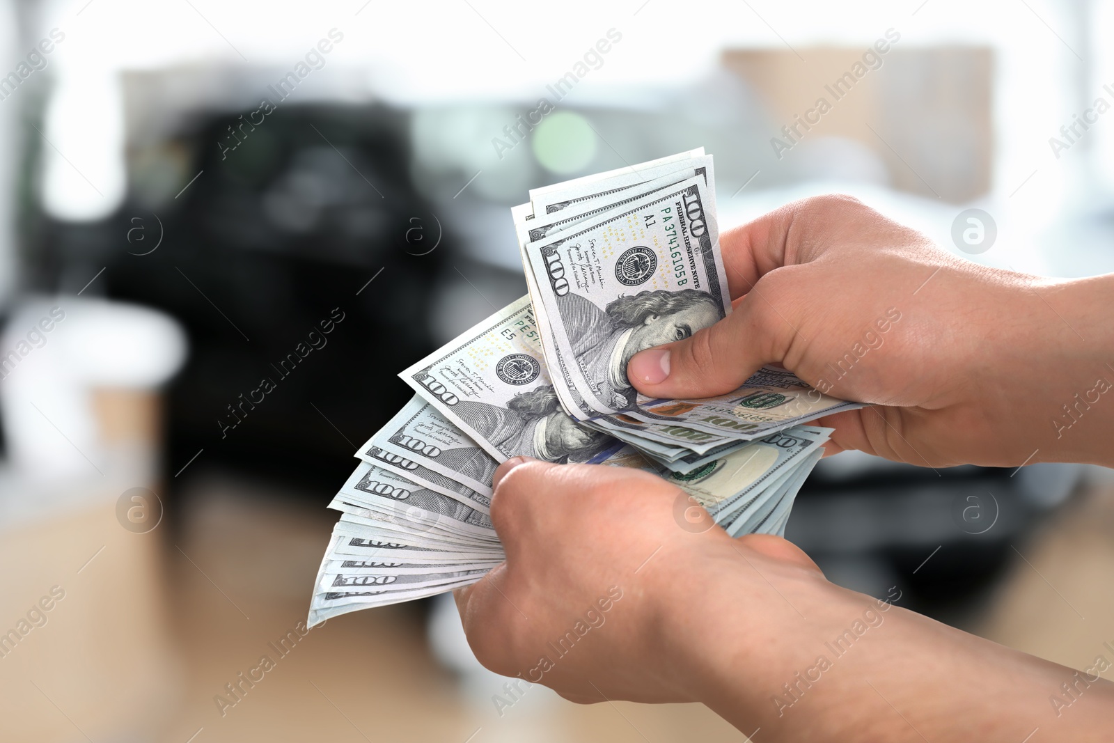 Image of Man with money in automotive shop, closeup. Buying car