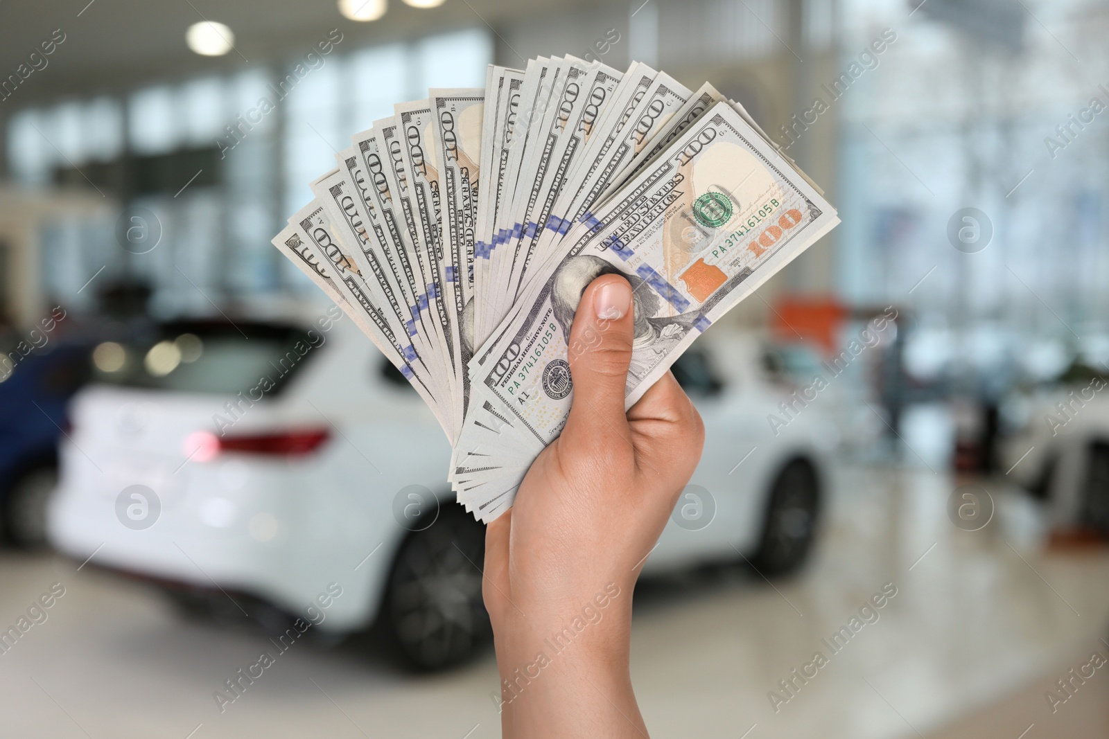 Image of Man with money in automotive shop, closeup. Buying car