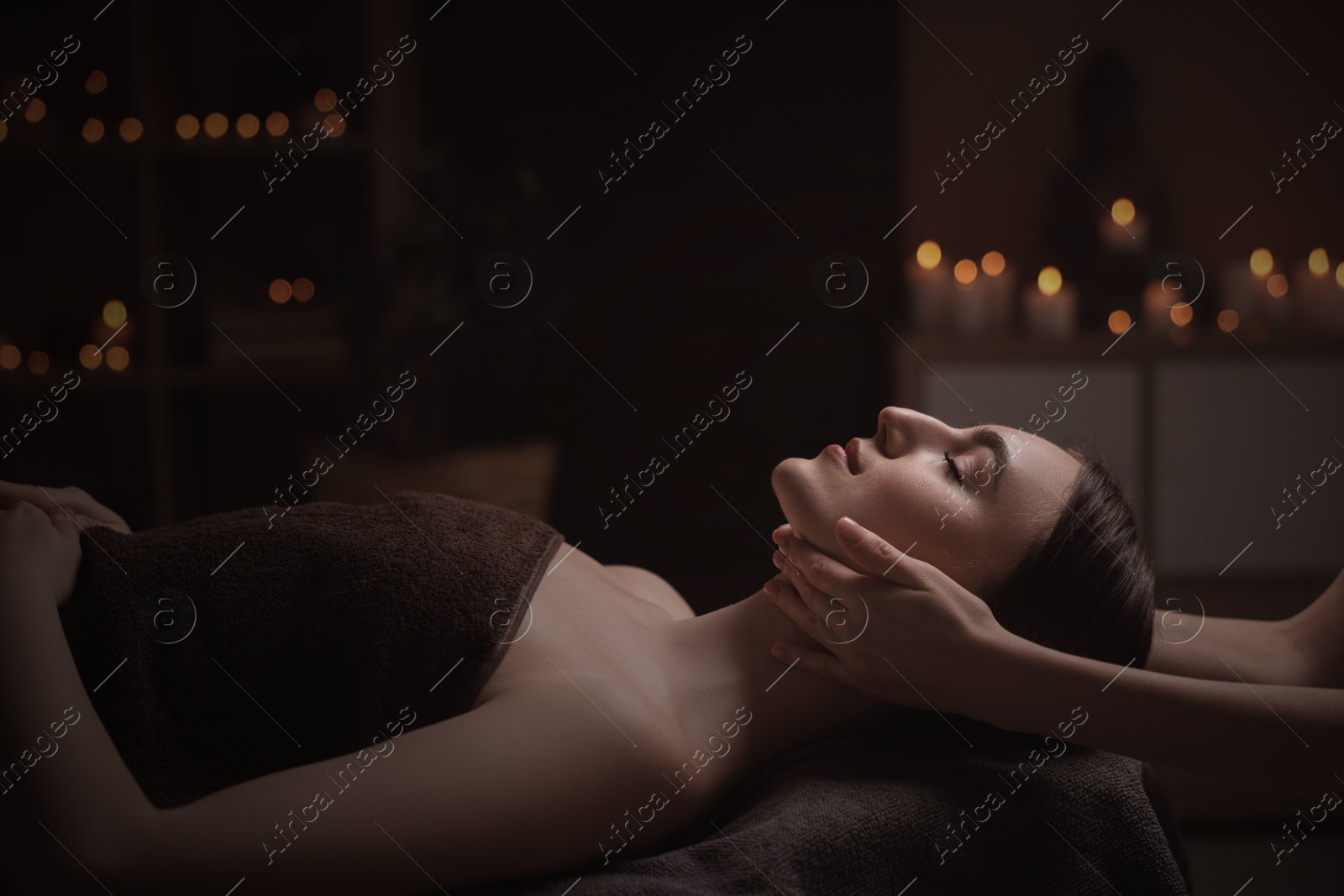 Image of Beautiful young woman lying on table during massage in salon