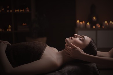 Image of Beautiful young woman lying on table during massage in salon