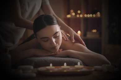 Image of Beautiful young woman lying on table during massage in salon