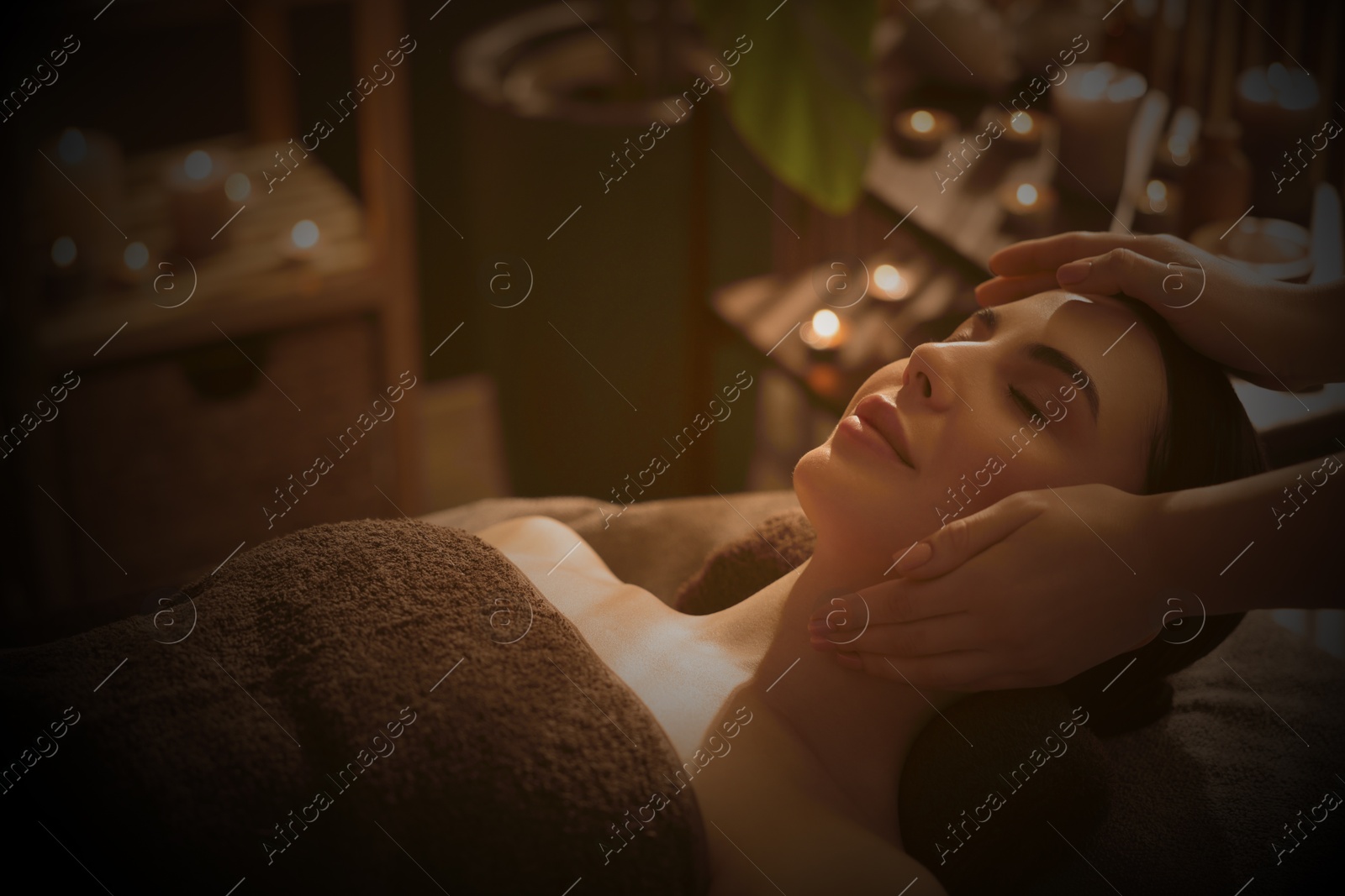 Image of Beautiful young woman lying on table during massage in salon