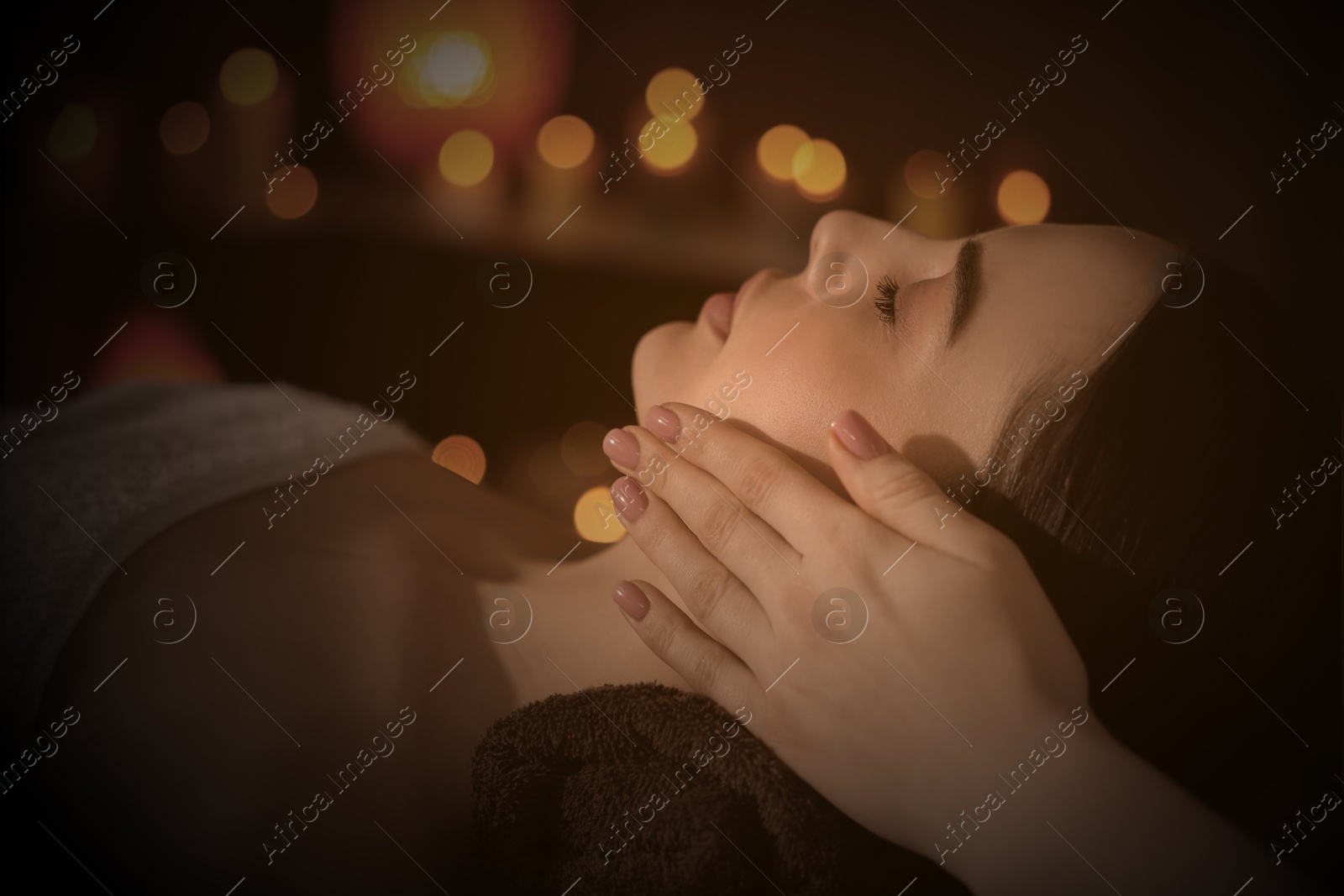 Image of Beautiful young woman lying on table during massage in salon