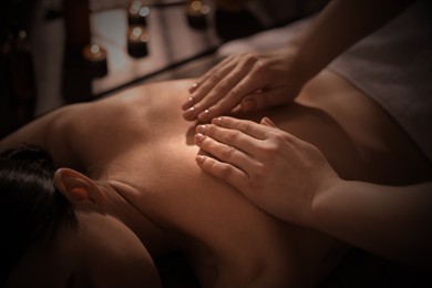 Image of Beautiful young woman lying on table during massage in salon, closeup