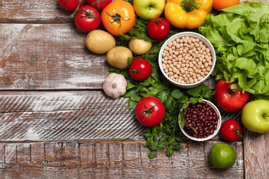 Photo of Different vegetarian products on wooden table, top view. Space for text