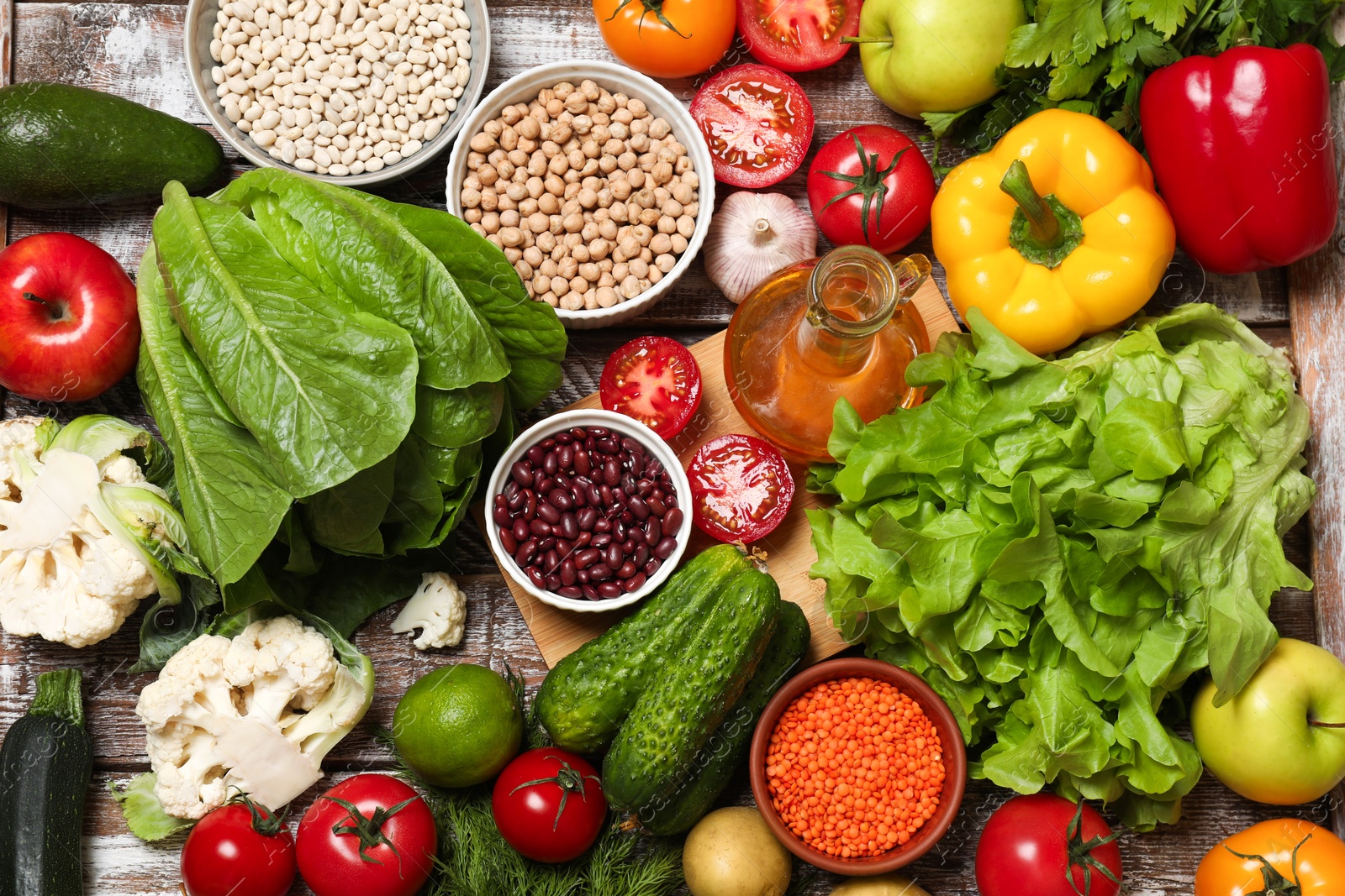 Photo of Different vegetarian products on wooden table, top view