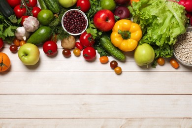 Photo of Different vegetarian products on light wooden table, top view. Space for text