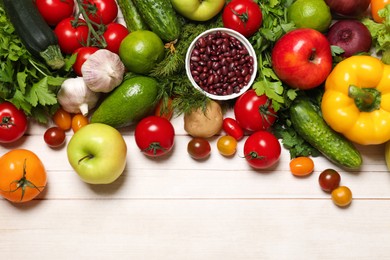 Photo of Different vegetarian products on light wooden table, top view. Space for text