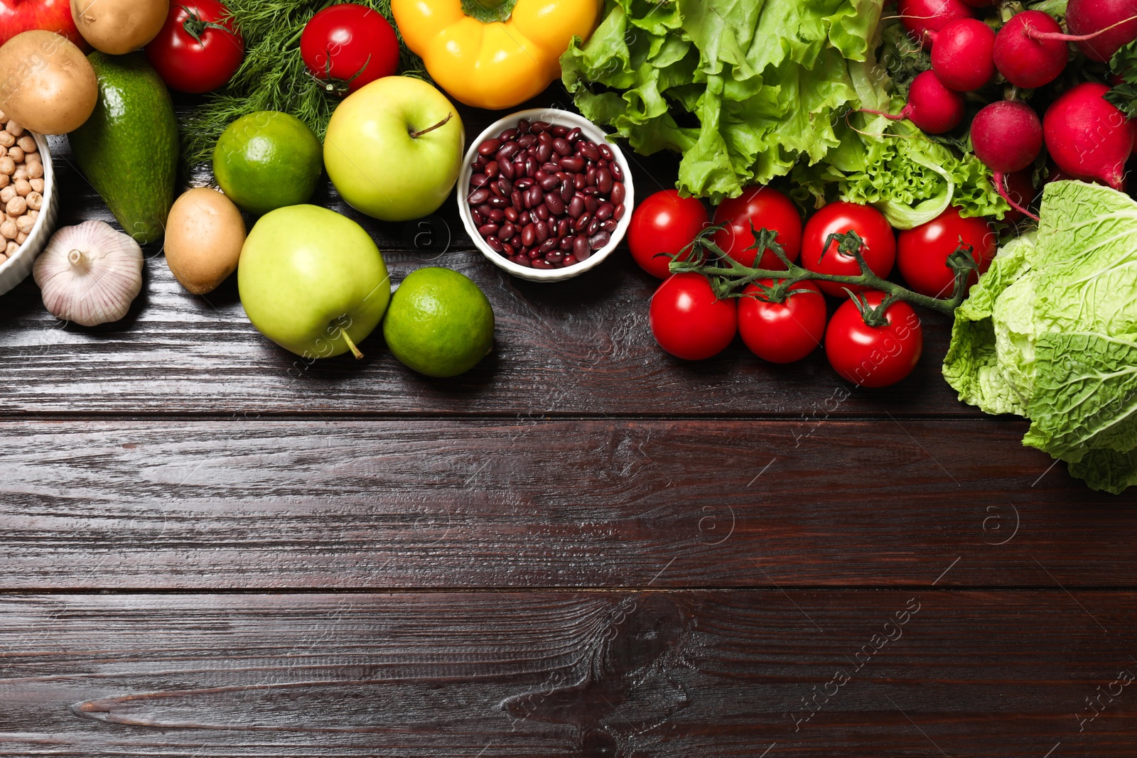 Photo of Different vegetarian products on wooden table, top view. Space for text