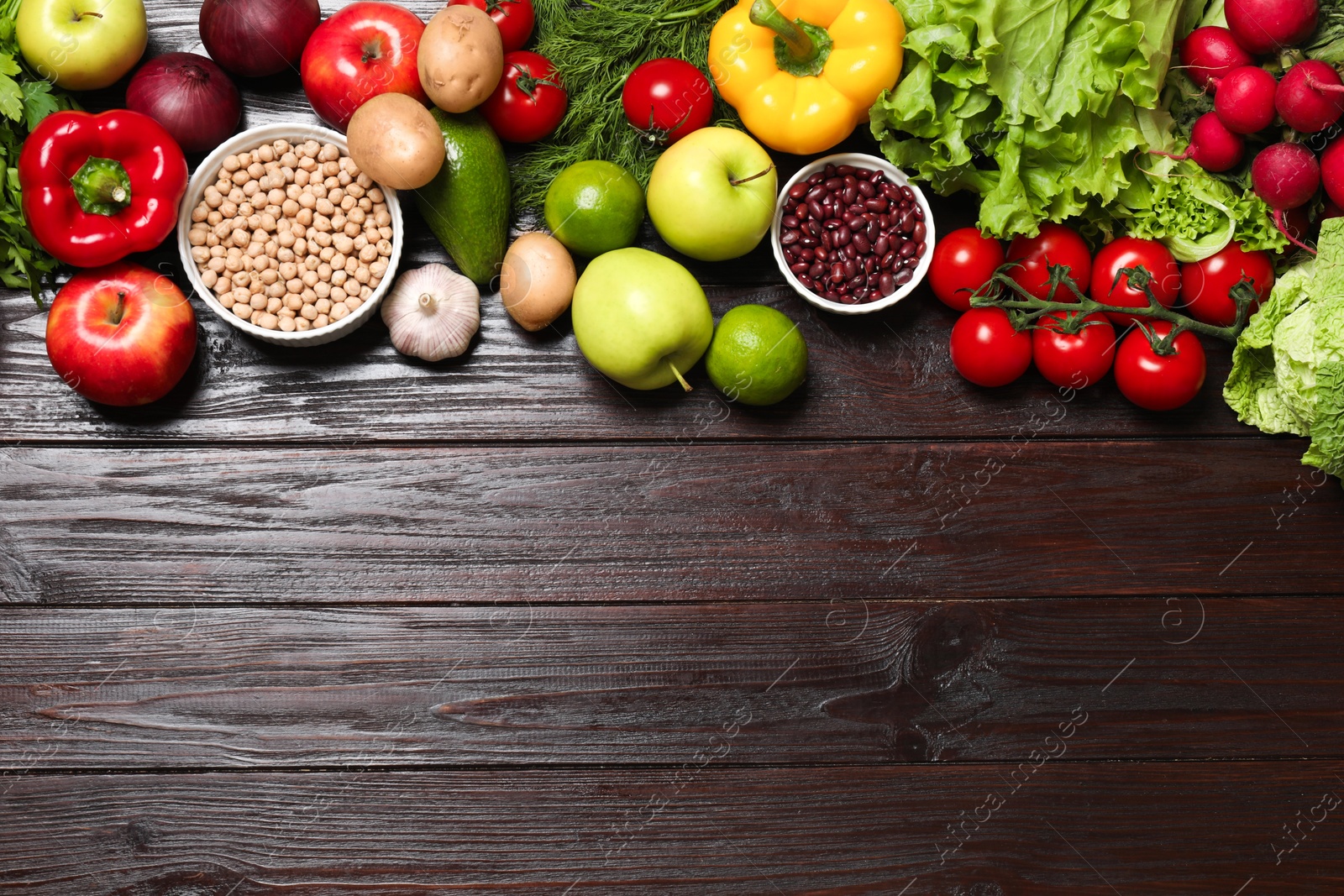 Photo of Different vegetarian products on wooden table, top view. Space for text