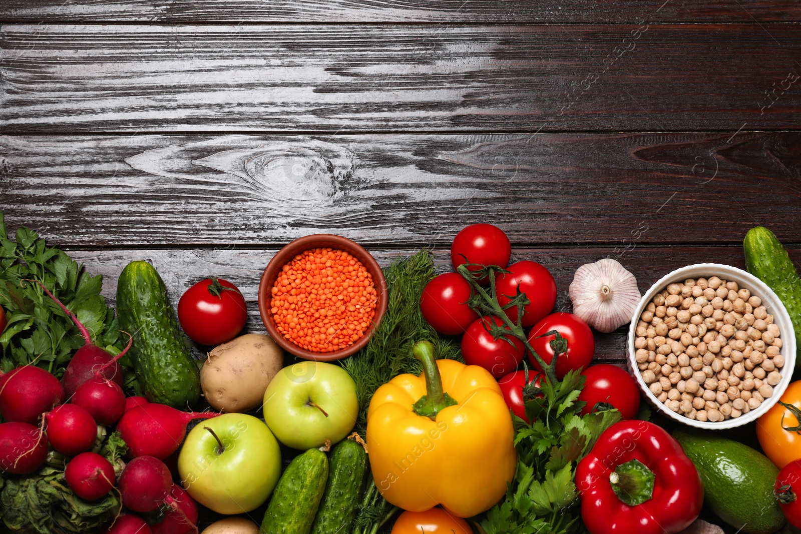 Photo of Different vegetarian products on wooden table, top view. Space for text