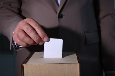 Photo of Man putting his vote into ballot box, closeup