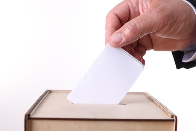 Photo of Man putting his vote into ballot box against white background, closeup