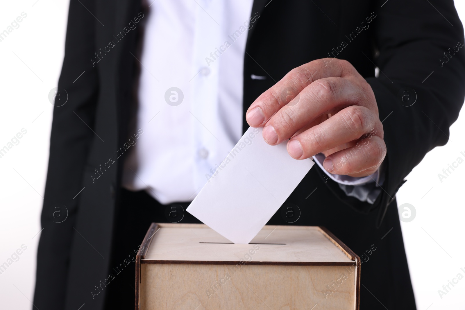 Photo of Man putting his vote into ballot box against white background, closeup