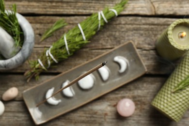 Photo of Flat lay composition with incense stick smoldering in holder on wooden table