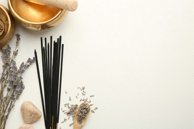 Photo of Incense sticks, Tibetan singing bowls, dry lavender flowers and stones on white table, flat lay. Space for text