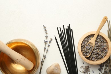 Photo of Incense sticks, Tibetan singing bowl, dry lavender flowers and stone on white table, flat lay. Space for text