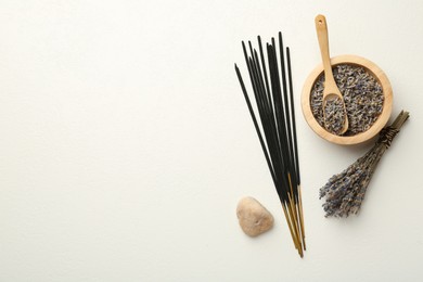Photo of Incense sticks, dry lavender flowers and stone on white table, flat lay. Space for text
