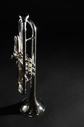 Shiny trumpet on dark background. Wind musical instrument
