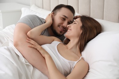Lovely couple enjoying time together in bed at morning