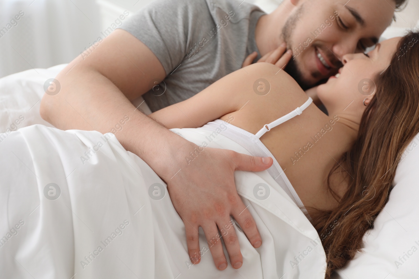 Photo of Lovely couple enjoying time together in bed at morning, closeup