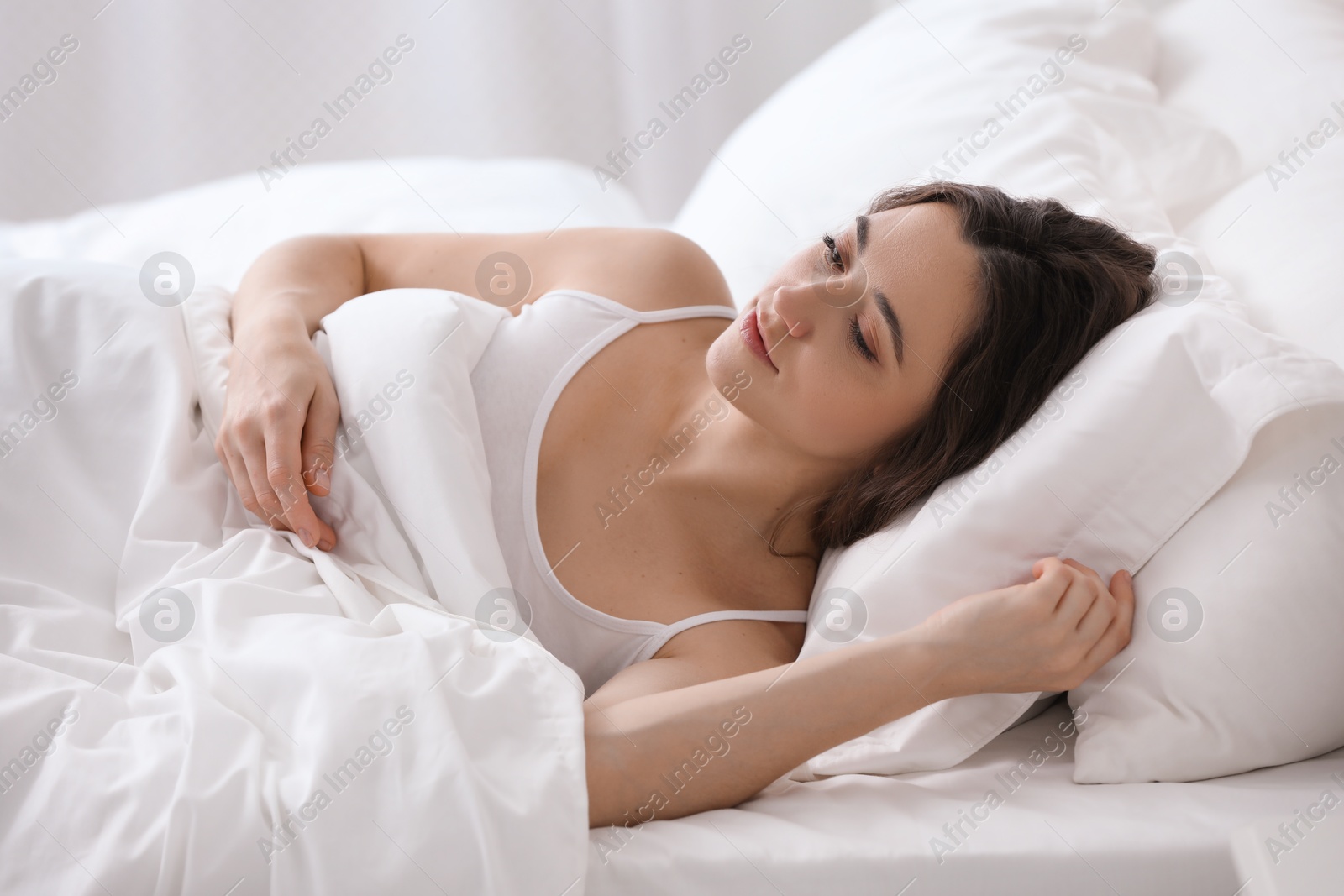 Photo of Bedtime. Beautiful woman lying in bed at home