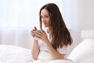 Photo of Woman drinking coffee in bed at home. Good morning