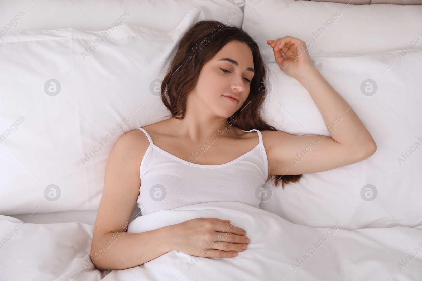 Photo of Bedtime. Beautiful woman sleeping in bed indoors, top view