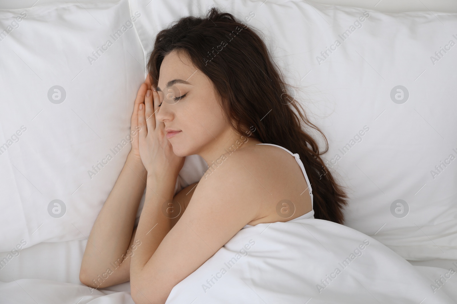 Photo of Bedtime. Beautiful woman sleeping in bed indoors, top view