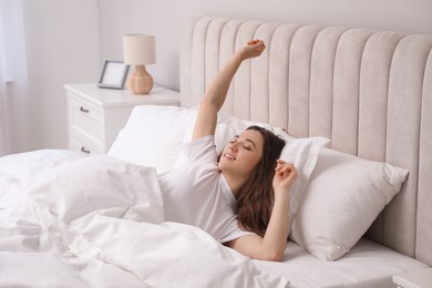 Photo of Happy woman lying in bed at home