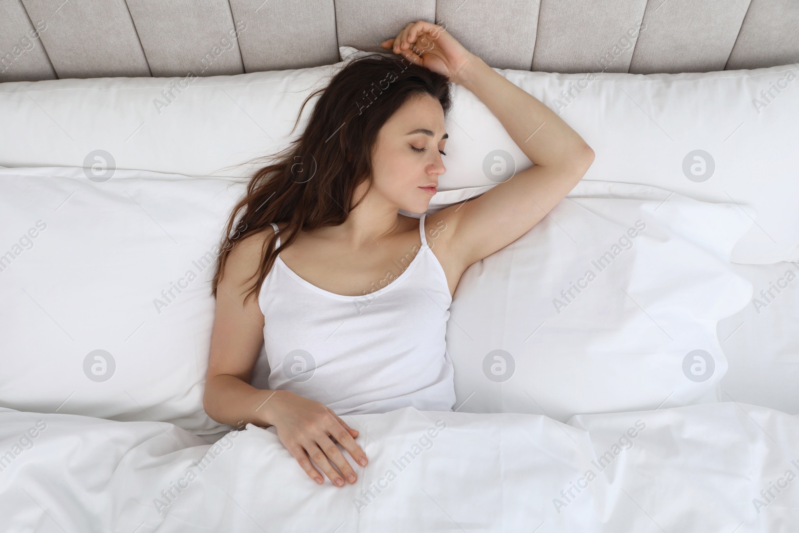 Photo of Bedtime. Beautiful woman sleeping on bed in morning, top view