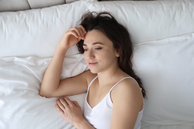 Photo of Bedtime. Beautiful woman lying on bed in morning, top view