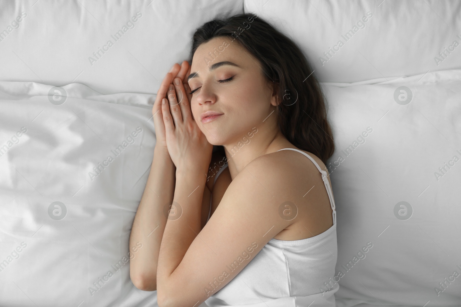 Photo of Bedtime. Beautiful woman sleeping on bed in morning, top view