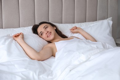 Photo of Smiling woman lying in bed at home
