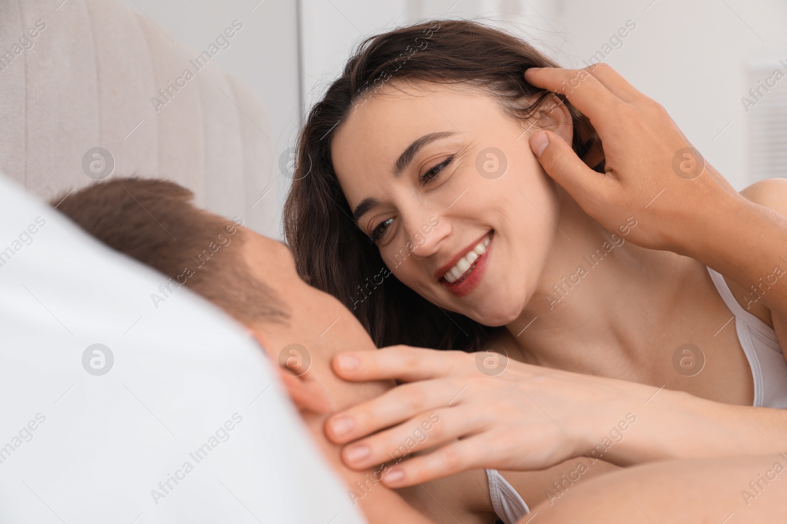 Photo of Happy couple spending time together in bed at home