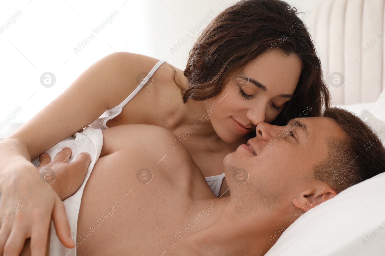 Photo of Lovely couple lying on bed at home