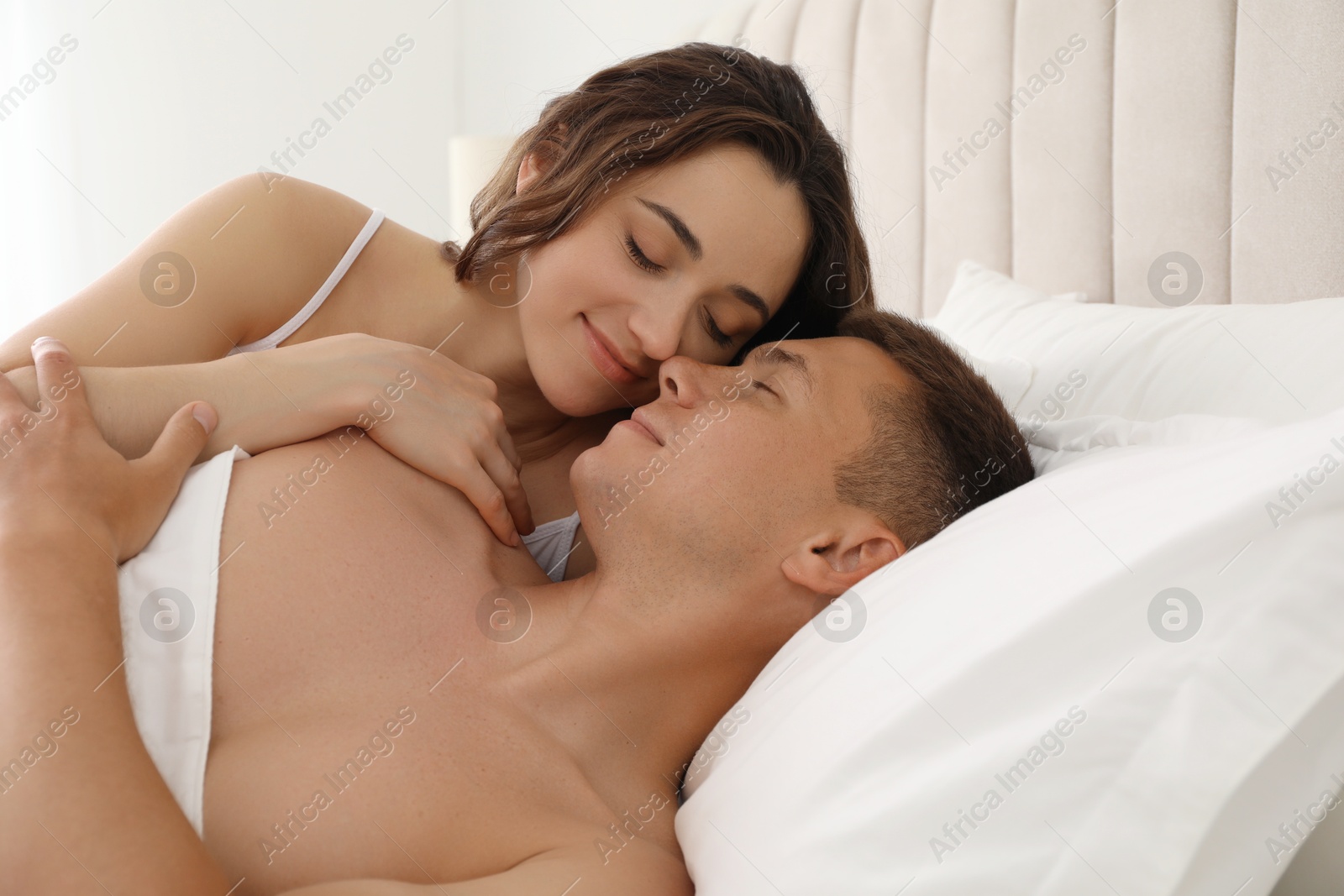 Photo of Lovely couple lying on bed at home
