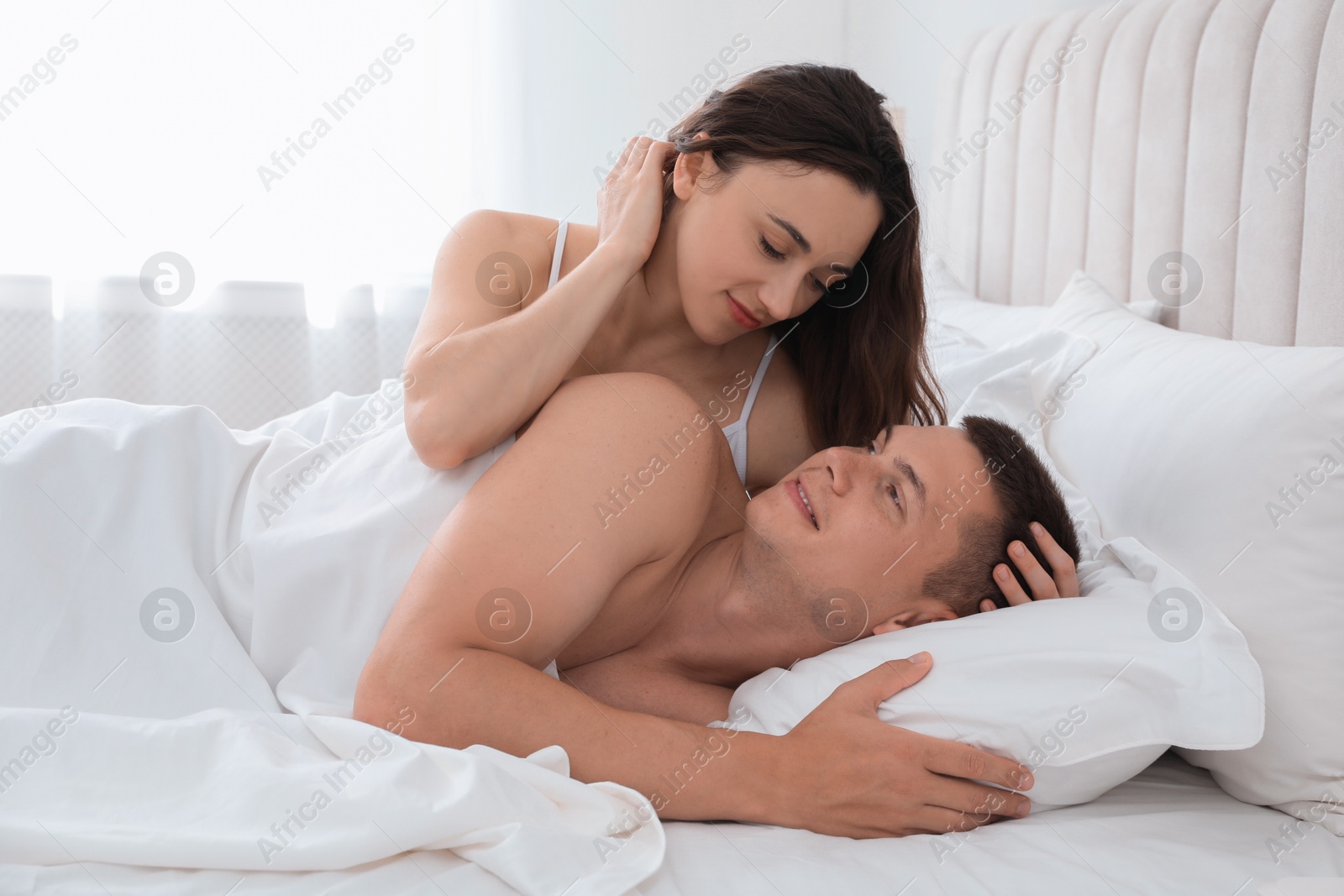 Photo of Lovely couple lying in bed at home