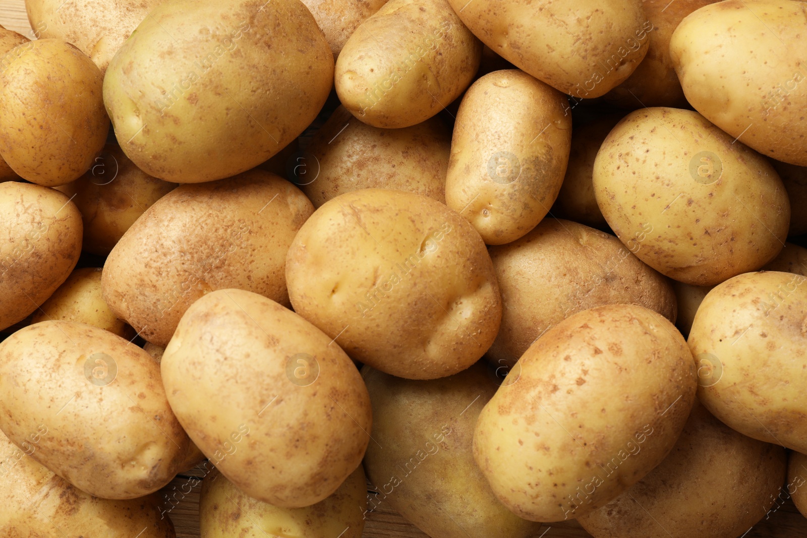 Photo of Many fresh potatoes as background, top view