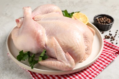 Photo of Fresh raw chicken with spices and lemon on light grey table