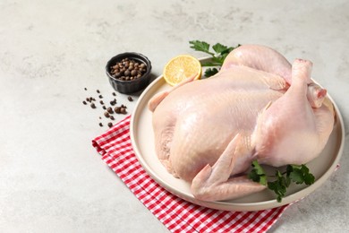 Photo of Fresh raw chicken with spices and lemon on light grey table