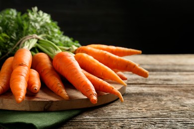 Tasty ripe juicy carrots on wooden table