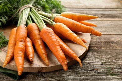 Photo of Tasty ripe juicy carrots on wooden table