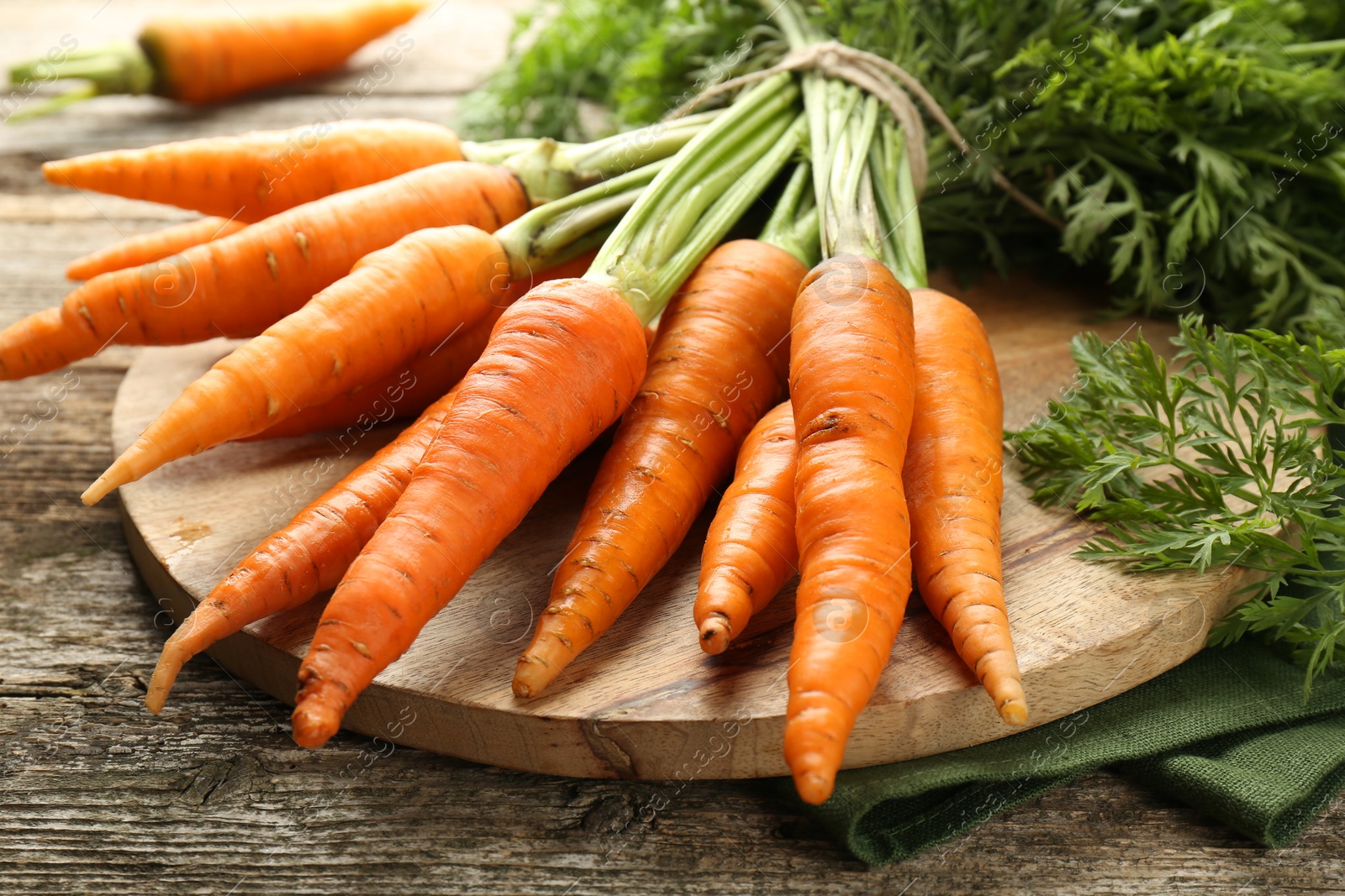 Photo of Tasty ripe juicy carrots on wooden table