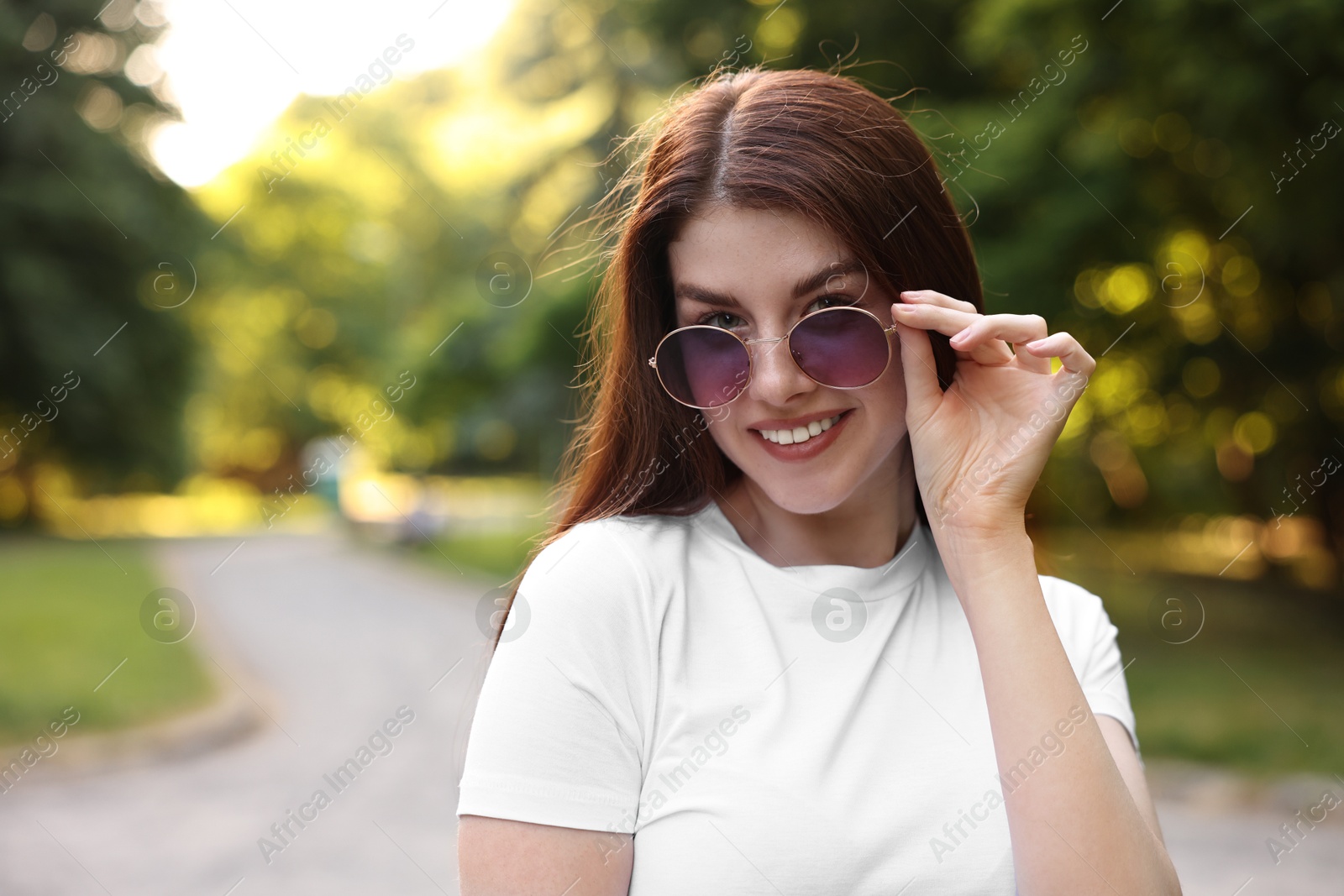 Photo of Portrait of smiling woman in sunglasses outdoors, space for text. Spring vibes